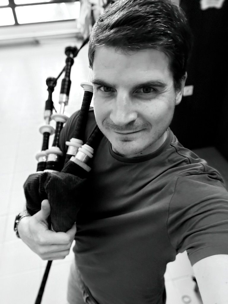 Scottish bagpiper in traditional attire performing music for an indoor wedding reception Scottish bagpiper in traditional attire performing music for an indoor wedding reception